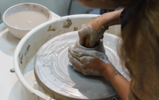 Pottery student shaping clay by hand in a PSAD studio