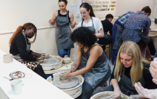 Pottery tutor demonstrating techniques to students at PSAD
